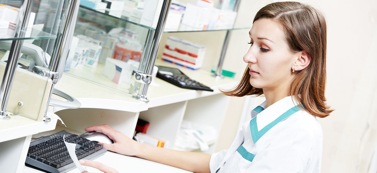 Pharmacy assistant typing on keyboard